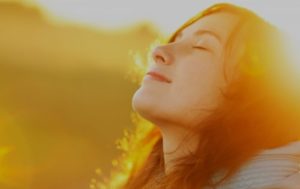 woman's face looking relaxed in a field