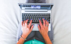 a close up of a person's hands typing on a computer