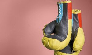 two boxing gloves hanging by string