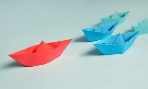 a paper boat leading several other boats